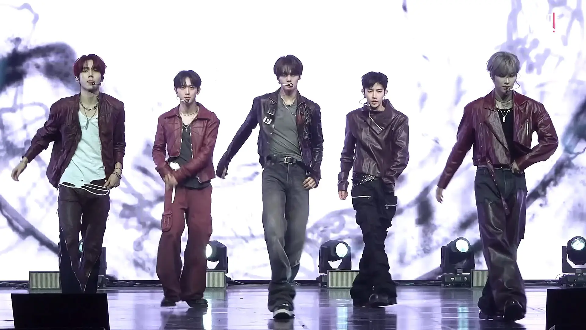 Five AND2BLE members in matching dark red outfits walking on stage