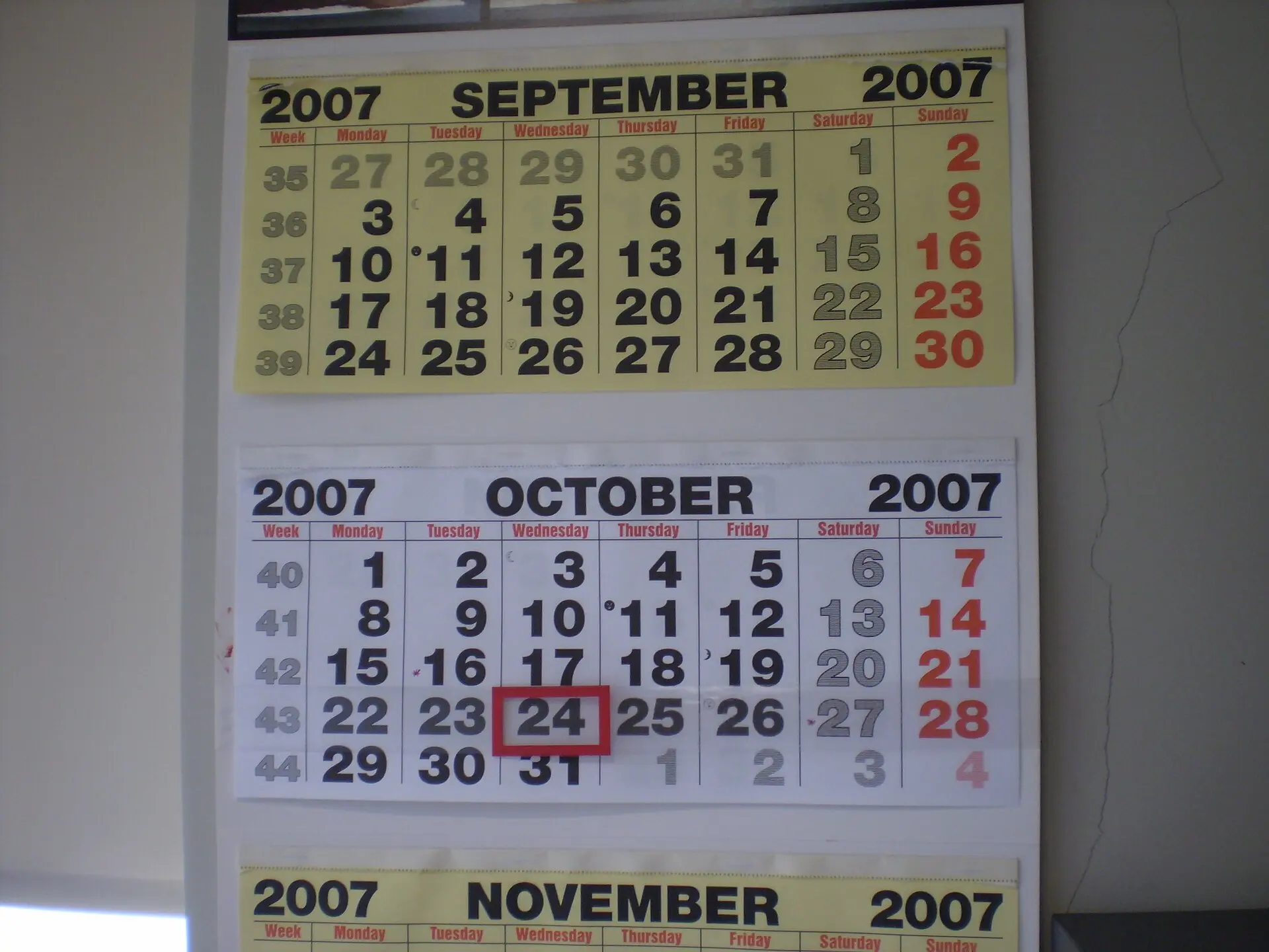 A wall calendar showing September, October and November with one date marked in red