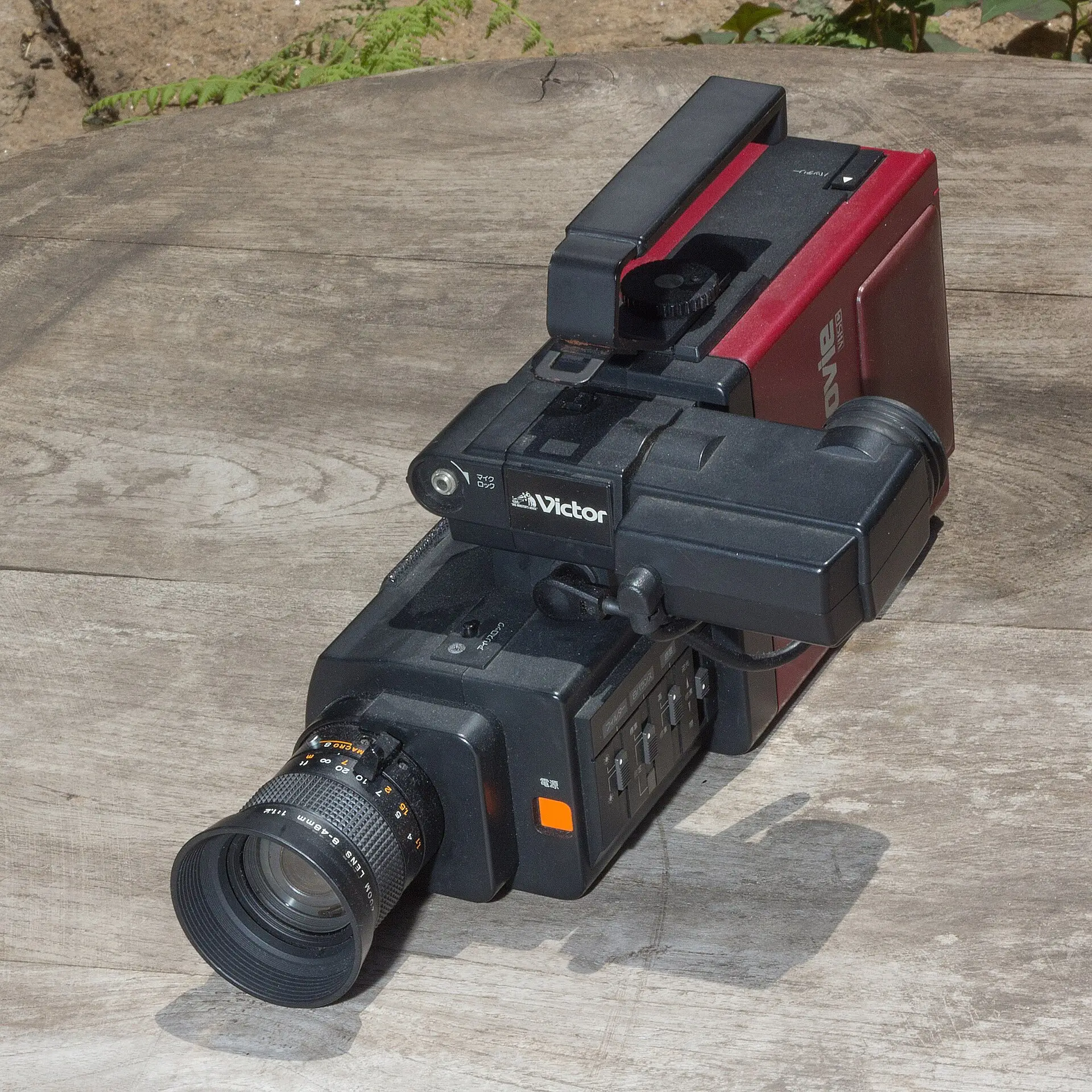 A vintage compact camcorder sitting on a wall