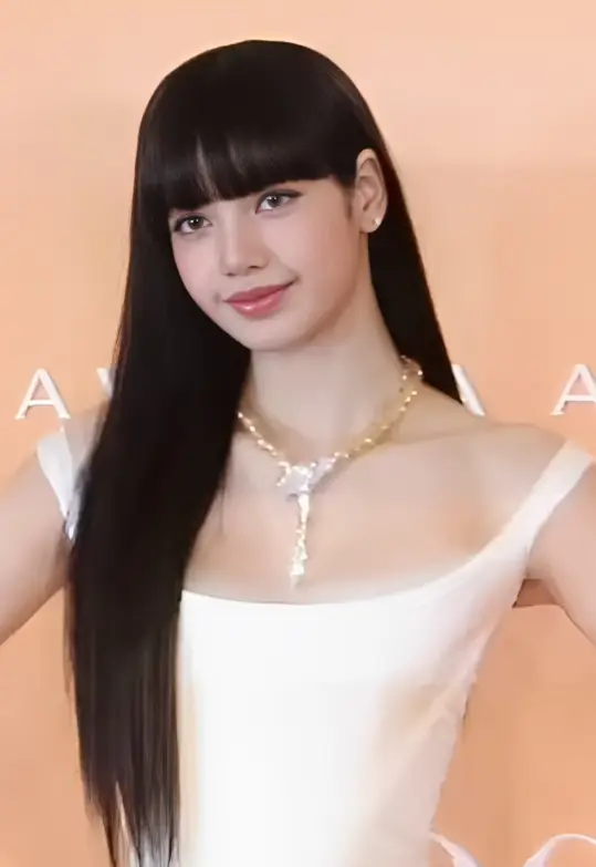 LISA smiling at a jewelry brand event, wearing a white dress and necklace