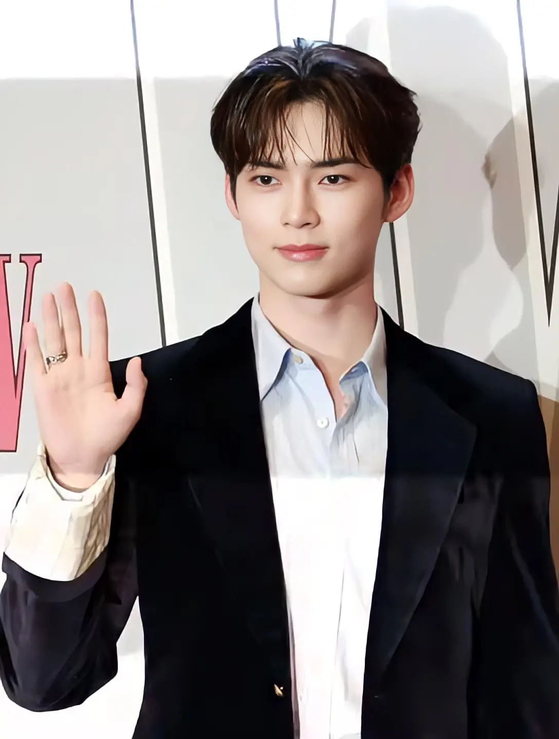 Sung Han-bin in a black suit waving at a brand event